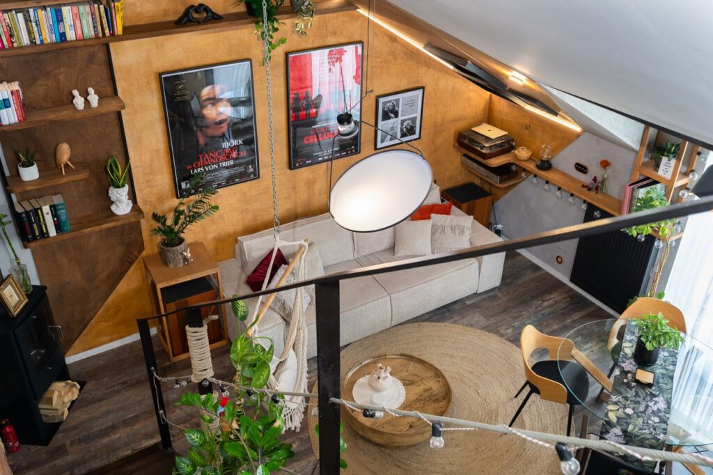 Stylish living room loft with modern decor, plants, and artwork, viewed from above.
