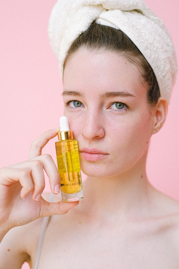 femme tenant un produit de beauté 