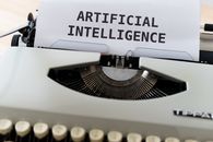 pexels-photo-4604607-4604607 machine a écrire avec une feuille ou il y a inscrit "artificial intelligence"