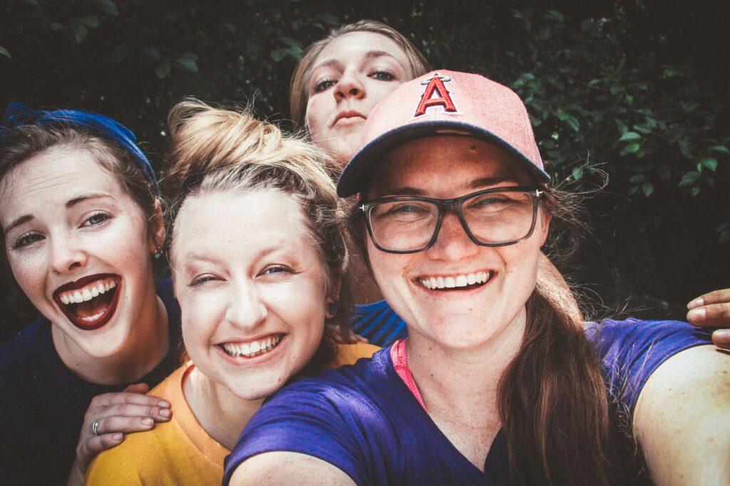 A joyful group of women taking a selfie outdoors, showcasing happiness and friendship.