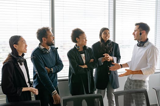 A diverse group of professionals having a conversation in a modern office environment.