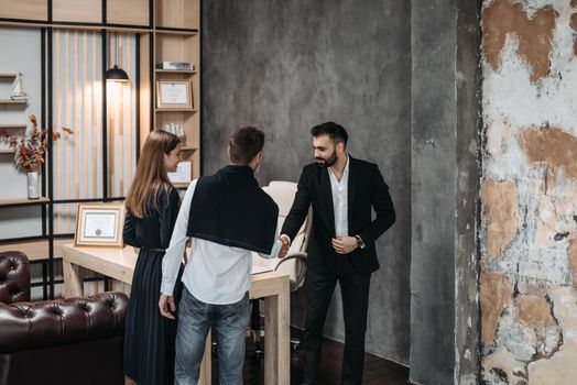 trois personne se rencontre et se serre la main pour une réunion entre des responsables commerciales et un fournisseurs 
