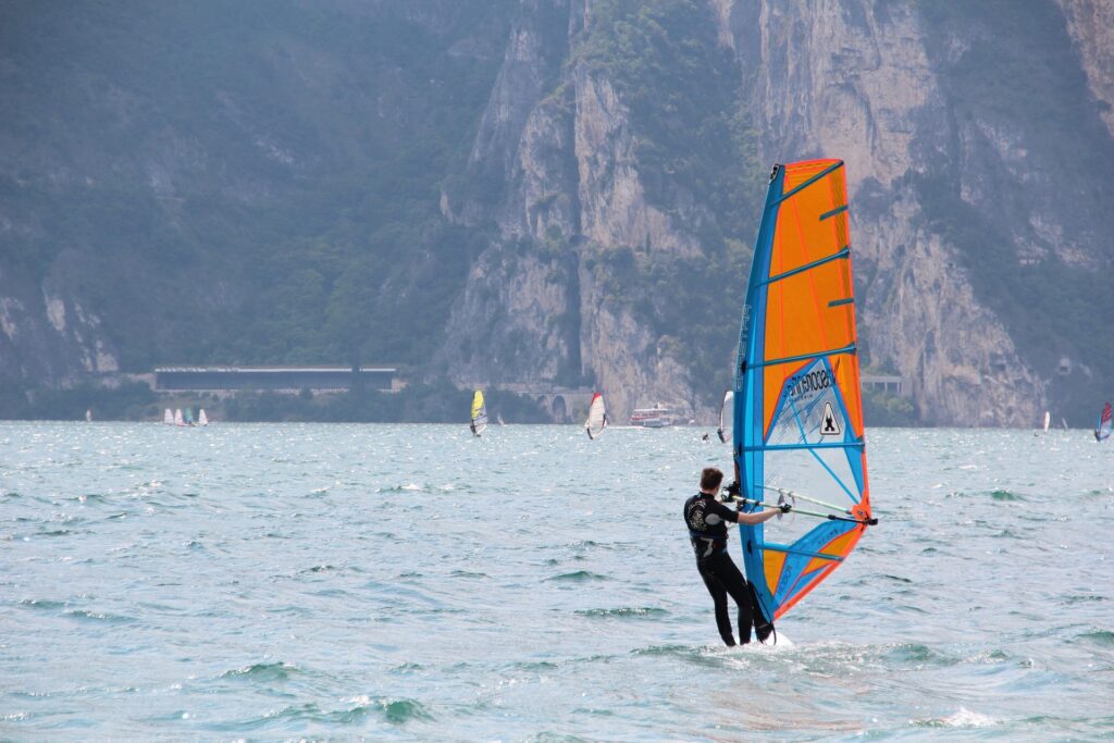 un cours de windsurf pour debutant avec le prof en premier plan et les élèves en second plan en train de s'entraîner