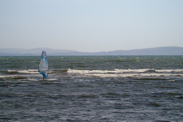 windsurfer au loin qui attaque une vague sous mauvais temps