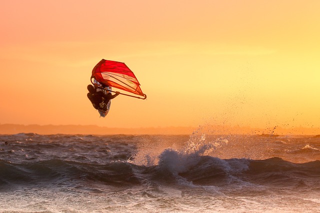 Windsurfer entrain de sauter une vague pendant un beau coucher de soleil
